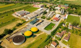 Luftaufnahme einer Biogasanlage neben Gewerbebetrieben und Feldern