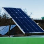 Solarmodule auf einem grünen Fahrzeugdach vor einer Straßenbrücke